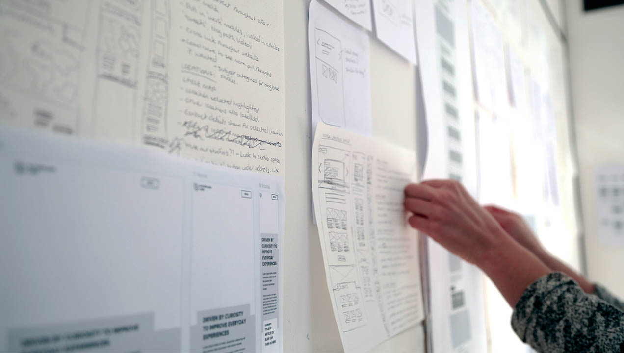 Photo of a range of wireframes pinned up on the wall.