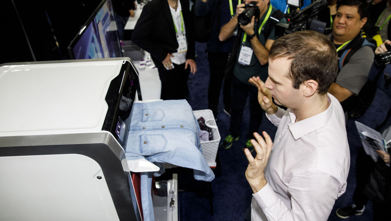 An attendee tries a FoldiMate Inc. robotic laundry folding machine during the CES Unveiled event. Patrick T. Fallon—Bloomberg via Getty Images