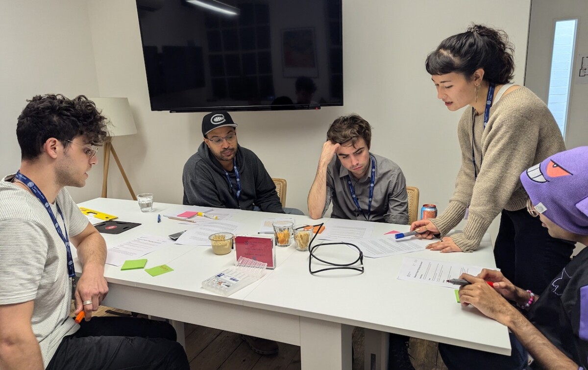 Five people working at a table on a game design